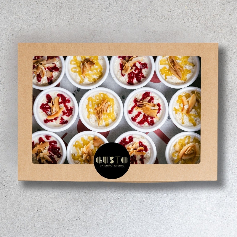 Box of assorted small desserts with 'Gusto' branding on a gray background