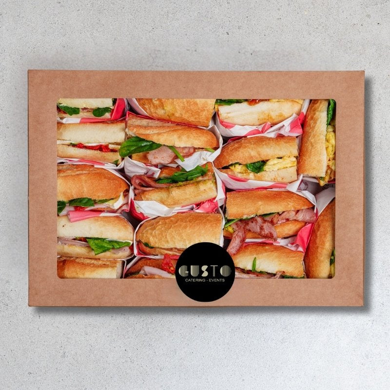 Box of assorted sandwiches with a visible 'Cafe Gusto' label on a gray background