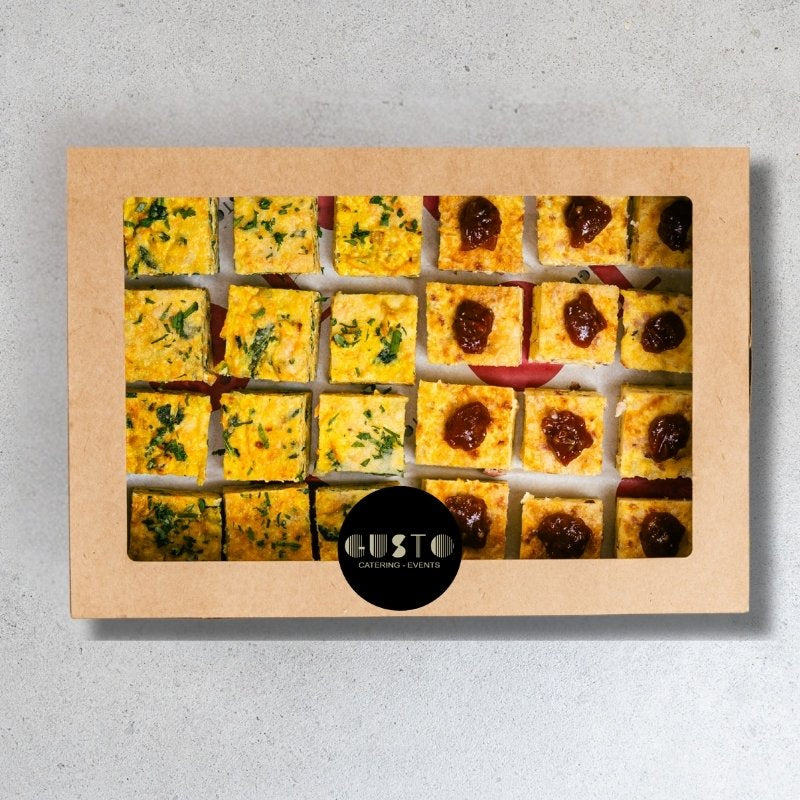 Box of assorted small frittata squares with 'Gusto' branding on a gray background