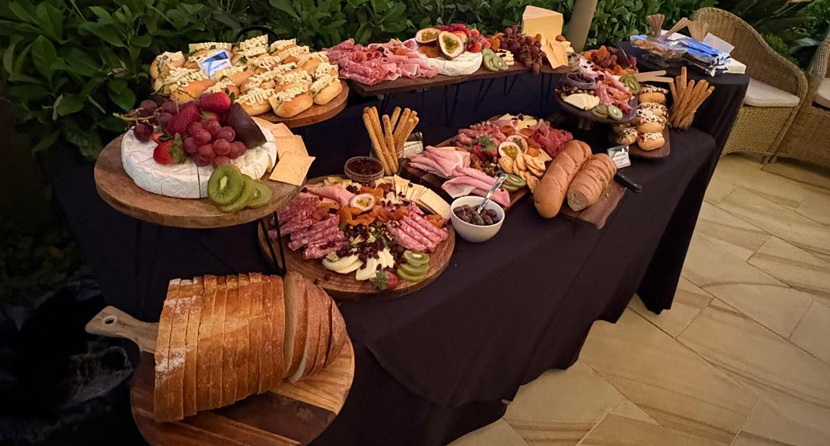 Outdoor setting with a table laden with various food items on a patio.