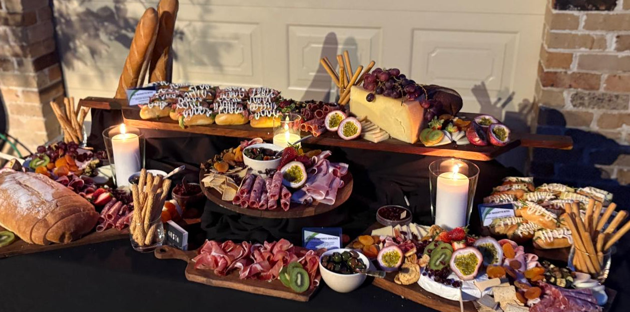 Outdoor setting with a table laden with various food items and candles.