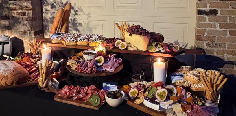 Outdoor food display on a table in front of a brick building at night.