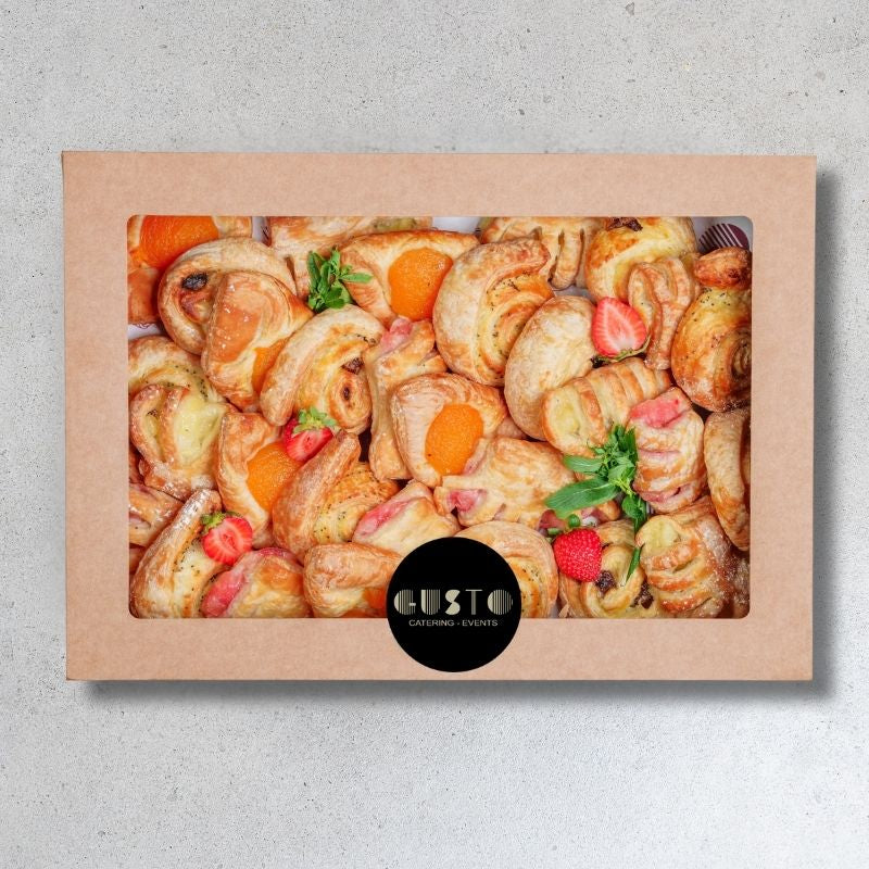 Box of pastries with visible brand 'Gusto' on a gray background