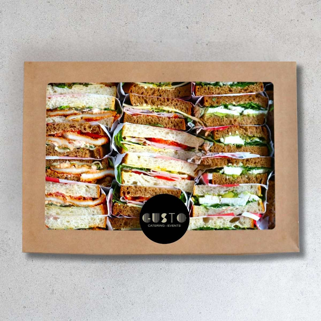 Box of assorted sandwiches on a gray background