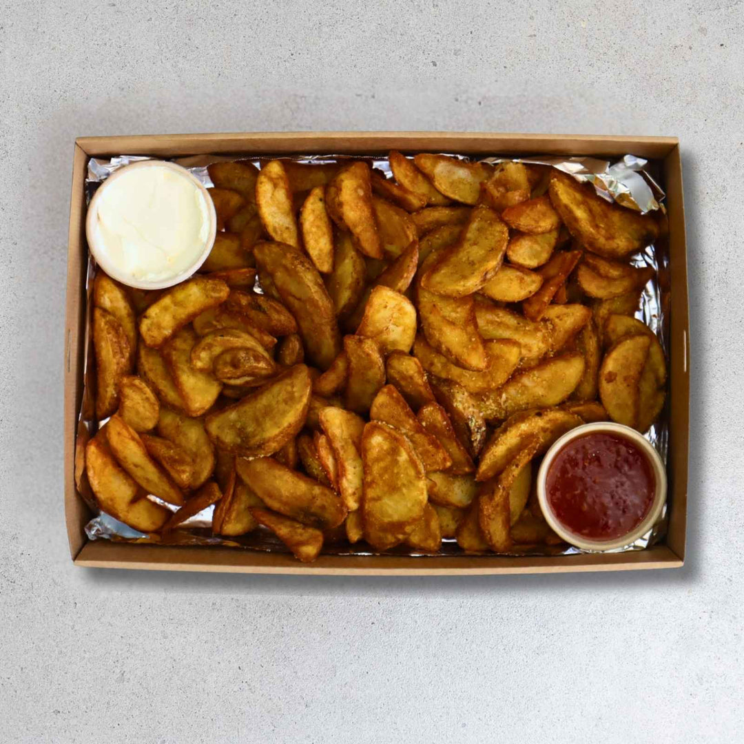 Box of fries with two dipping sauces on a gray background